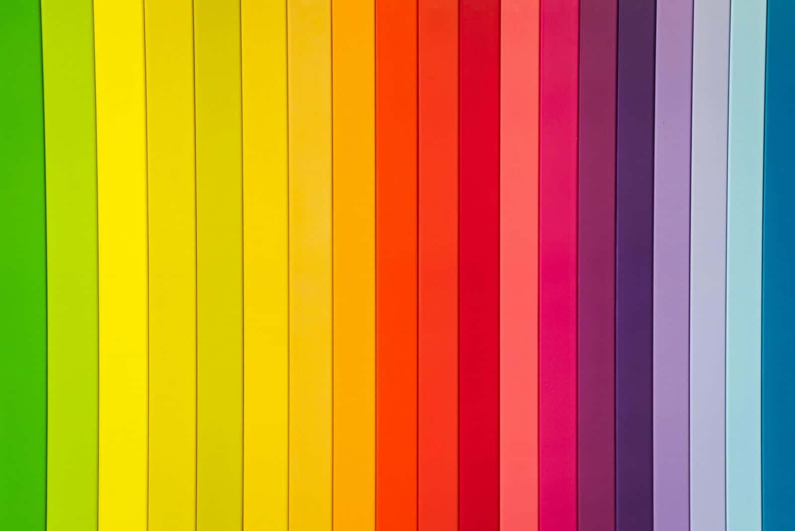 A vibrant, striped pattern consisting of vertical lines in various colors of the rainbow, including green, yellow, orange, red, pink, purple, and blue. The lines are of equal width and create a bright, colorful, and symmetrical design.